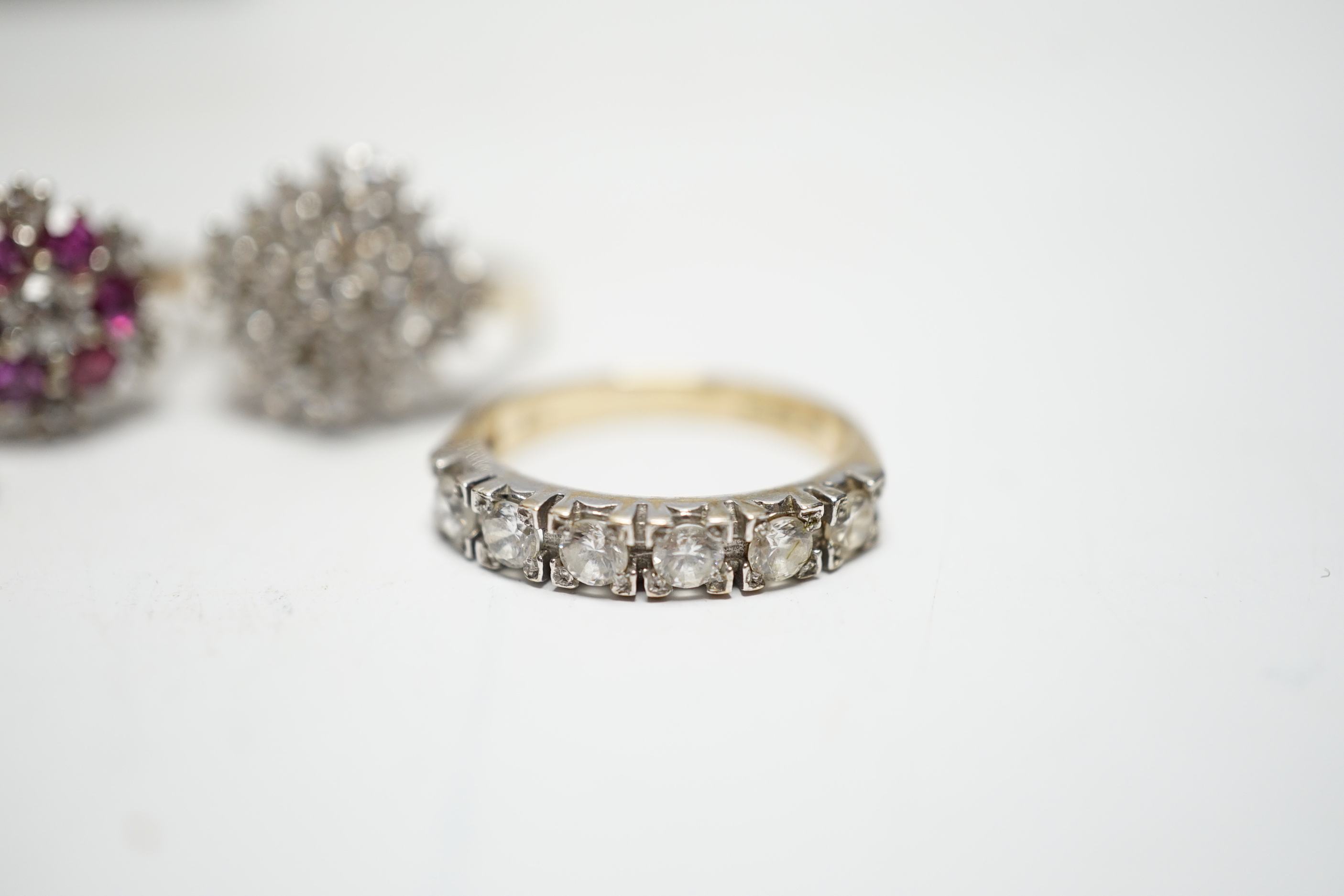 A modern 9ct gold, ruby and simulated diamond cluster set flower head ring, size N and three other assorted 9ct rings including CZ and two colour paste, gross weight 12.4 grams.